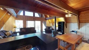 a living room with a large table in a cabin at Elk Run A-frame House With Hot Tub And High Speed Wifi in Red River