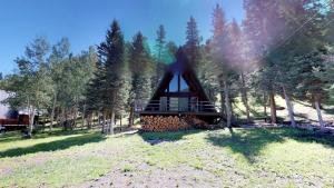 a small cabin in the woods with a tree at Elk Run A-frame House With Hot Tub And High Speed Wifi in Red River