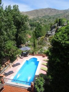 a large blue swimming pool with a view of a mountain at Cortijo La Mata in Granada