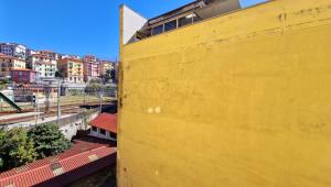 un muro giallo accanto a una città con edifici di Onda su Onda a La Spezia