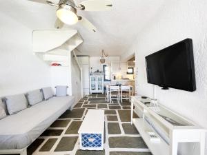 a living room with a couch and a flat screen tv at Ocean Vibes Villa by Angels Group Mykonos in Mýkonos City