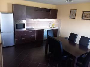 eine Küche mit einem Tisch und einem weißen Kühlschrank in der Unterkunft Apartment Filipovic in Podgorica