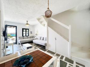 a living room with a staircase and a couch at Ocean Vibes Villa by Angels Group Mykonos in Mýkonos City +32 photos