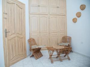 Habitación con 2 sillas, mesa y puerta en Dar Beya ( APP S+2 ) en Tozeur