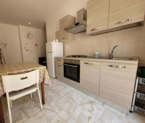 a kitchen with a table and a white refrigerator at Villa S.Antonio in Ascea