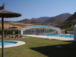 a group of people sitting around a swimming pool at La Reposada in Ardales