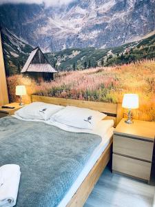 a bedroom with a large bed with a mountain view at Szczyrkowskie SKI & FUN 3 z balkonem - Sauna i Jacuzzi in Szczyrk