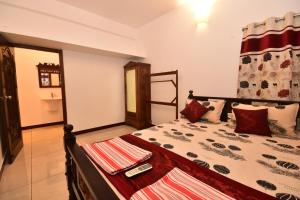 a bedroom with a large bed with red pillows at Dj Villa in Puducherry