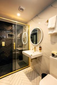 a bathroom with a shower and a sink and a mirror at The Ferryman Townhouse in Dublin