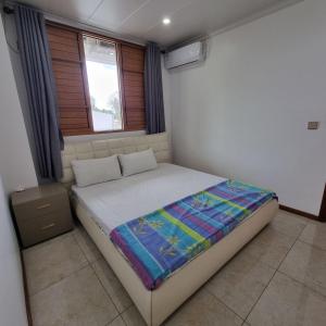 Bett in einem Zimmer mit Fenster in der Unterkunft Nena Accomodations in Nadi