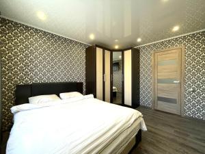 une chambre avec un grand lit blanc dans une pièce dans l'établissement Вокзал ТД Пирамида 2-х комнатная квартира, à Petropavlovsk-Kamtchatski