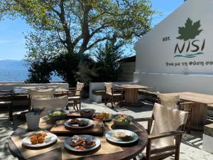 una mesa con platos de comida en el patio en Nisi Glamping, en Paralía Rachon