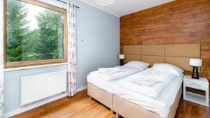 um quarto com uma cama e uma janela em Apartamenty Sun & Snow Bawaria II em Szklarska Poręba