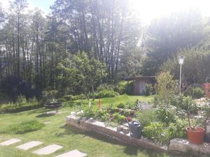 a garden with a stone wall and some plants at Sonnenloft Else und Studio Luise in Neubeuern