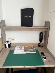 a desk with a phone and a book on it at Hotel Breitner in Rotterdam