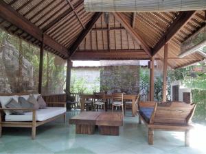 a pavilion with a couch and tables and chairs at Villa 7, Secret Garden, Kerandangan, near Senggigi in Mataram