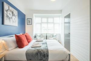 een slaapkamer met een groot wit bed met oranje kussens bij Stylish Studio 4 with Kitchenette by CB Stays no minimum stays in Cambridge