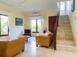 a living room with two chairs and a staircase at Villa 7, Secret Garden, Kerandangan, near Senggigi in Mataram