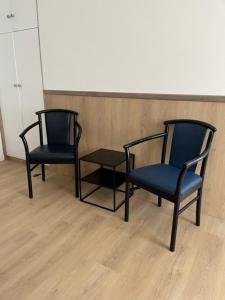 two chairs and a table in a room at Hotel Breitner in Rotterdam