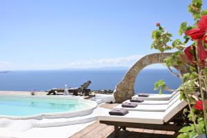 a group of lounge chairs next to a swimming pool at Villa Fos in Fanari