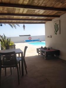 einen Tisch und Stühle sowie eine Tischtennisplatte und einen Pool in der Unterkunft Vivienda Vacacional Casa del Erizo - Ecofinca in Nazaret