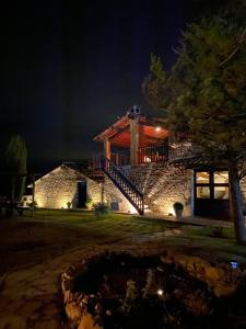 una casa de piedra por la noche con una hoguera en El Querol Vell en Borredá