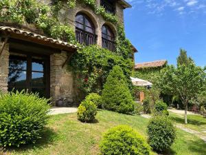 a house with ivy growing on the side of it at El Querol Vell in Borredá