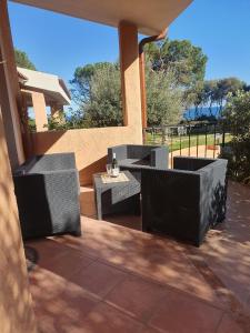 um pátio com 2 mesas e cadeiras num pátio em Villetta Porto Corallo Vista Mare em Villaputzu