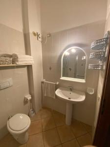 uma casa de banho com um lavatório, um WC e um espelho. em Villetta Porto Corallo Vista Mare em Villaputzu