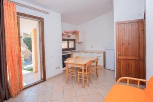 uma cozinha com mesa e cadeiras num quarto em Villetta Porto Corallo Vista Mare em Villaputzu