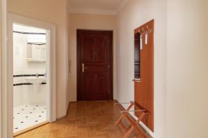 ein Flur mit einer Tür zu einem Badezimmer mit Waschbecken in der Unterkunft Sibelius Apartments in Prag + 76 Fotos