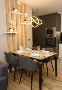 een eetkamer met een tafel met stoelen en een kroonluchter bij Modern Seaside Retreat 1BD Apartments in Varna