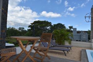 a wooden table and chairs on a deck with a table and chairs at Cap Sud Apartment in Tamarin