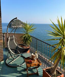 un columpio en un balcón con vistas al océano en Casa Isola, en Bergeggi