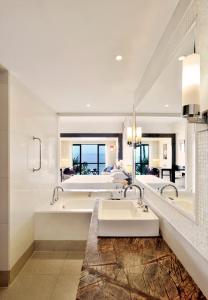 سبا ومنتجع غوا ماريوت في باناجي: حمام به مغسلتين ومرآة كبيرة