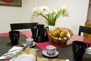 ローマにあるCorner Houseの食器・カップ・花のバスケット付きテーブル