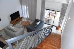 a living room with a couch and a television at Cap Sud Apartment in Tamarin