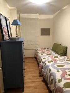 - une chambre avec un lit et une commode avec une lampe dans l'établissement Fantástico apartamento con garaje en Valdoviño., à Valdoviño