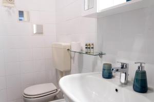 a white bathroom with a toilet and a sink at - ARENA - Panoramic VIEW - Central Apartment in Verona +11 photos