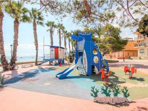 un parque infantil con tobogán en un parque con palmeras en Appealing holiday home in Roldan with garden, en Roldán