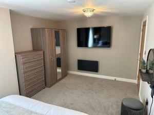 a bedroom with a dresser and a flat screen tv at Beach Pad - ground floor - pet friendly in Cleveleys