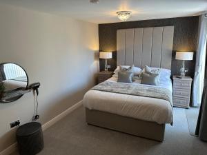 1 dormitorio con 1 cama grande y espejo en Beach Pad - ground floor - pet friendly en Cleveleys