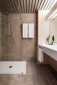 ein Bad mit einer Dusche und einem Waschbecken in der Unterkunft Hotel De Ruwenberg Den Bosch - Sint Michielsgestel in Sint Michielsgestel