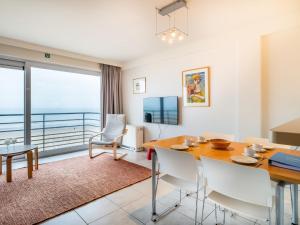 ein Esszimmer mit einem Tisch und Meerblick in der Unterkunft Attractive apartment in Koksijde with balcony in Koksijde