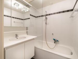 ein weißes Bad mit einer Dusche und einem Waschbecken in der Unterkunft Attractive apartment in Koksijde with balcony in Koksijde