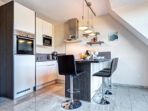 une cuisine avec un comptoir et deux tabourets dans l'établissement Residenz am Balmer See - BS 67 mit Wellnessbereich, à Balm