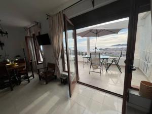 a dining room with a table and an umbrella at A little paradise with super views in Almuñecar in Almuñécar