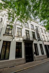 ein weißes Gebäude mit schwarzen Türen und Fenstern in der Unterkunft BTFL Living Antwerp in Antwerpen