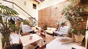 een patio met stoelen, tafels en planten bij Hotel Boutique 3 Poniente in Viña del Mar
