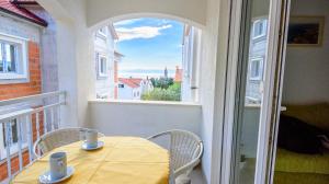 a table and chairs on a balcony with a window at Apartments Mija in Bol